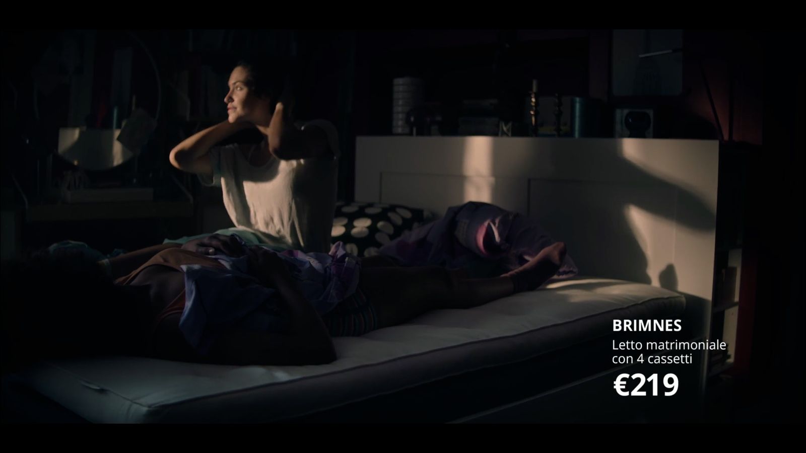 a person laying on a bed in a dark room