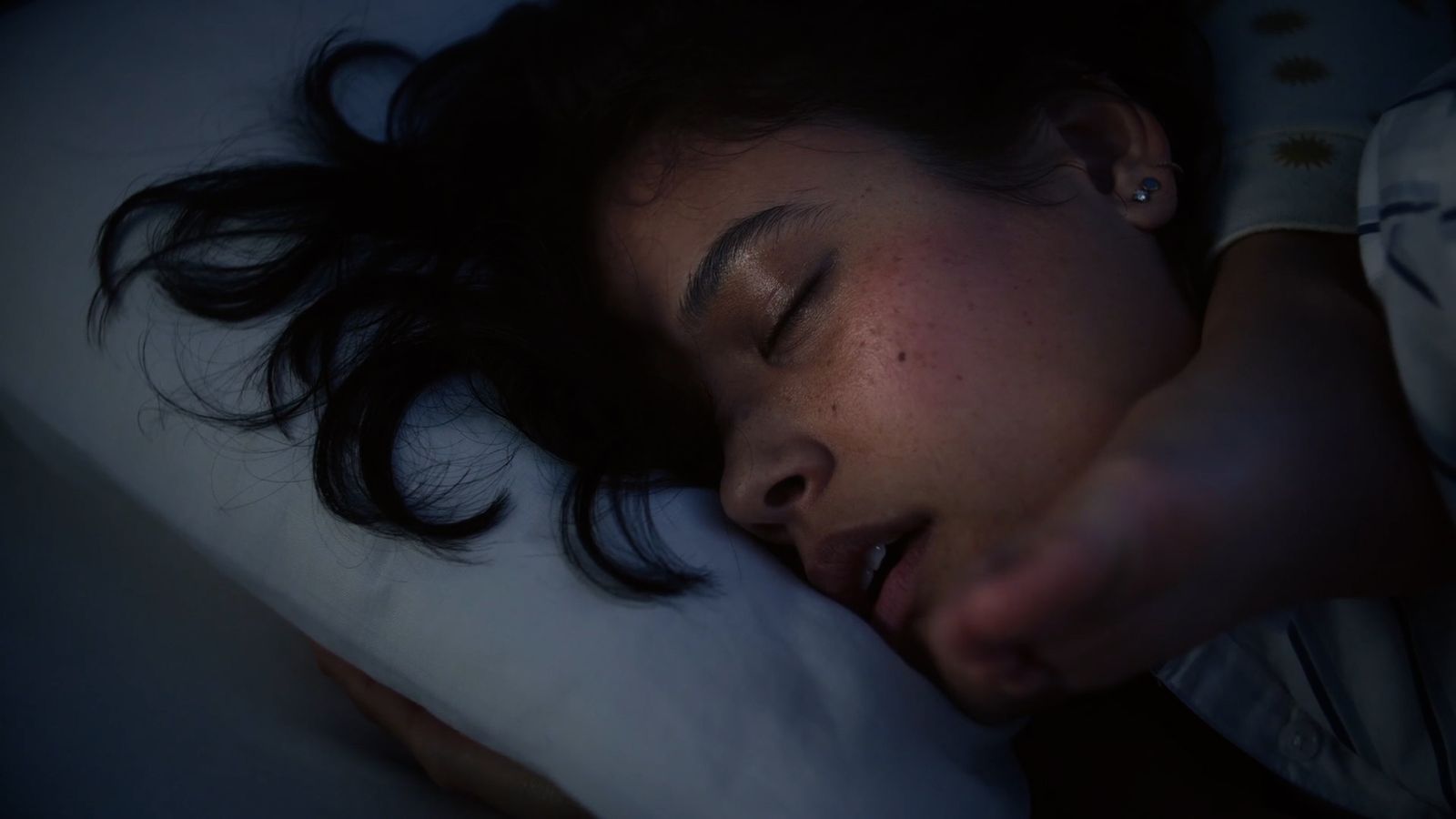 a woman laying in bed with her eyes closed