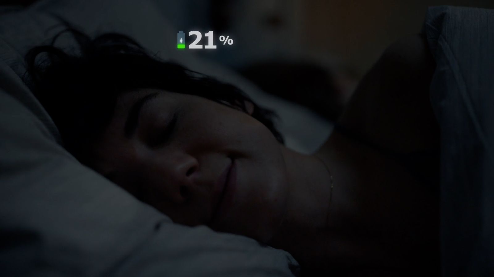 a woman sleeping in a bed with a thermometer in the background