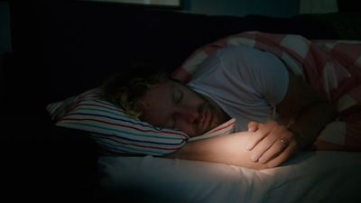 a woman is sleeping on a couch with her head on a pillow