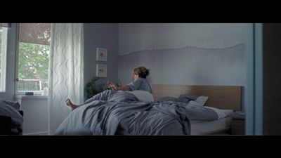 a woman sitting on a bed in a bedroom