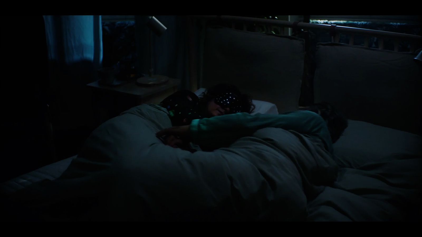 a person laying in a bed in a dark room