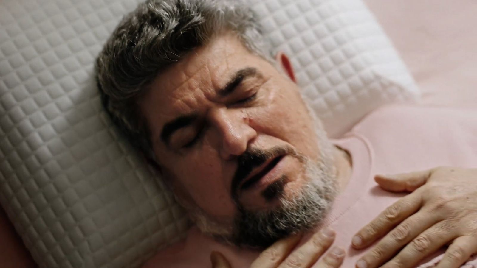 a man laying in bed with his eyes closed