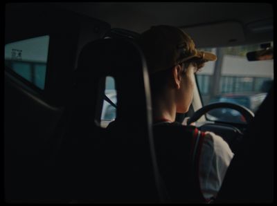 a person sitting in a car with a hat on