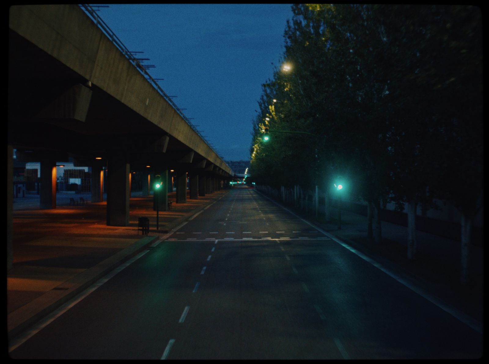 a city street at night with green lights