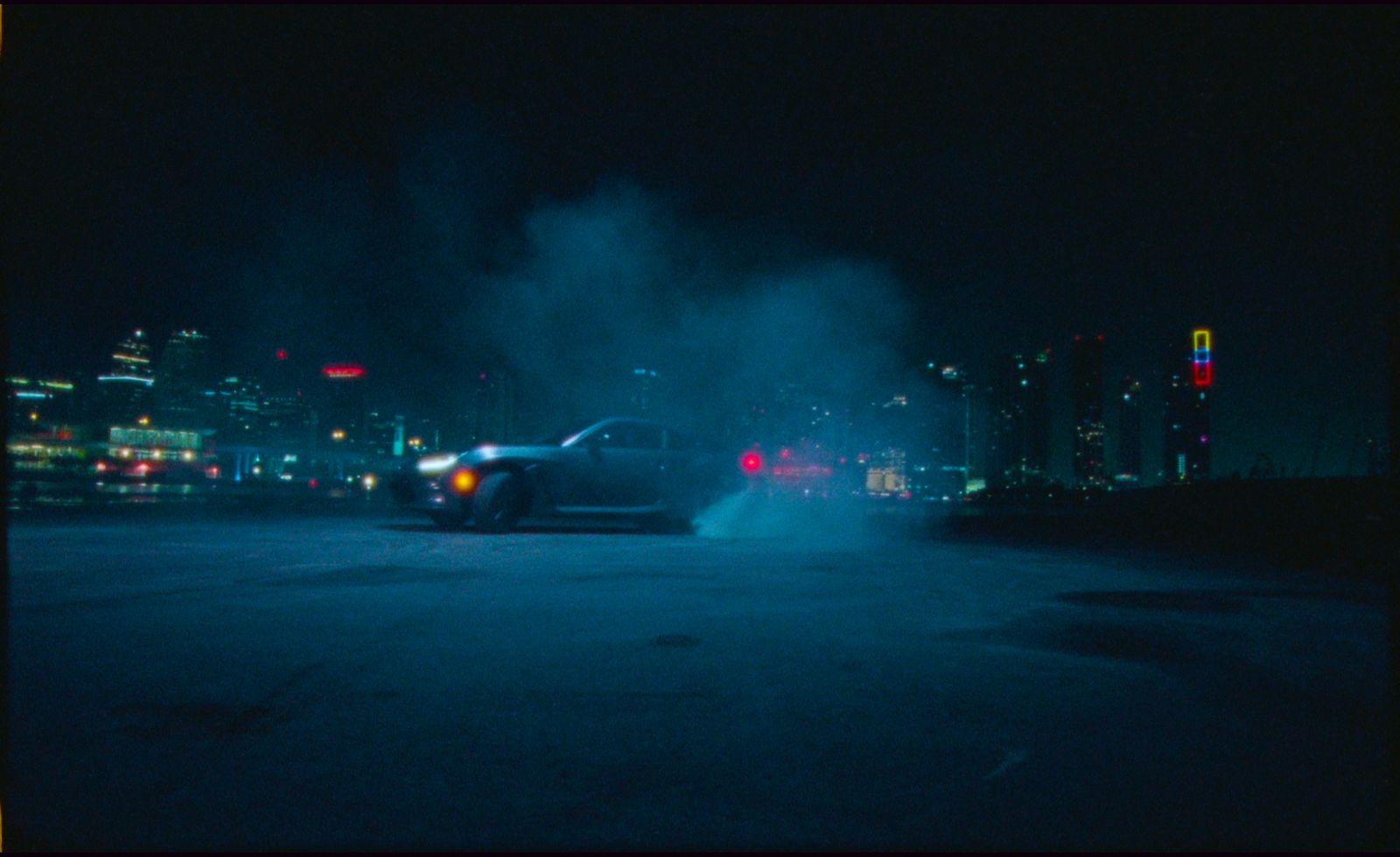 a car driving down a street at night