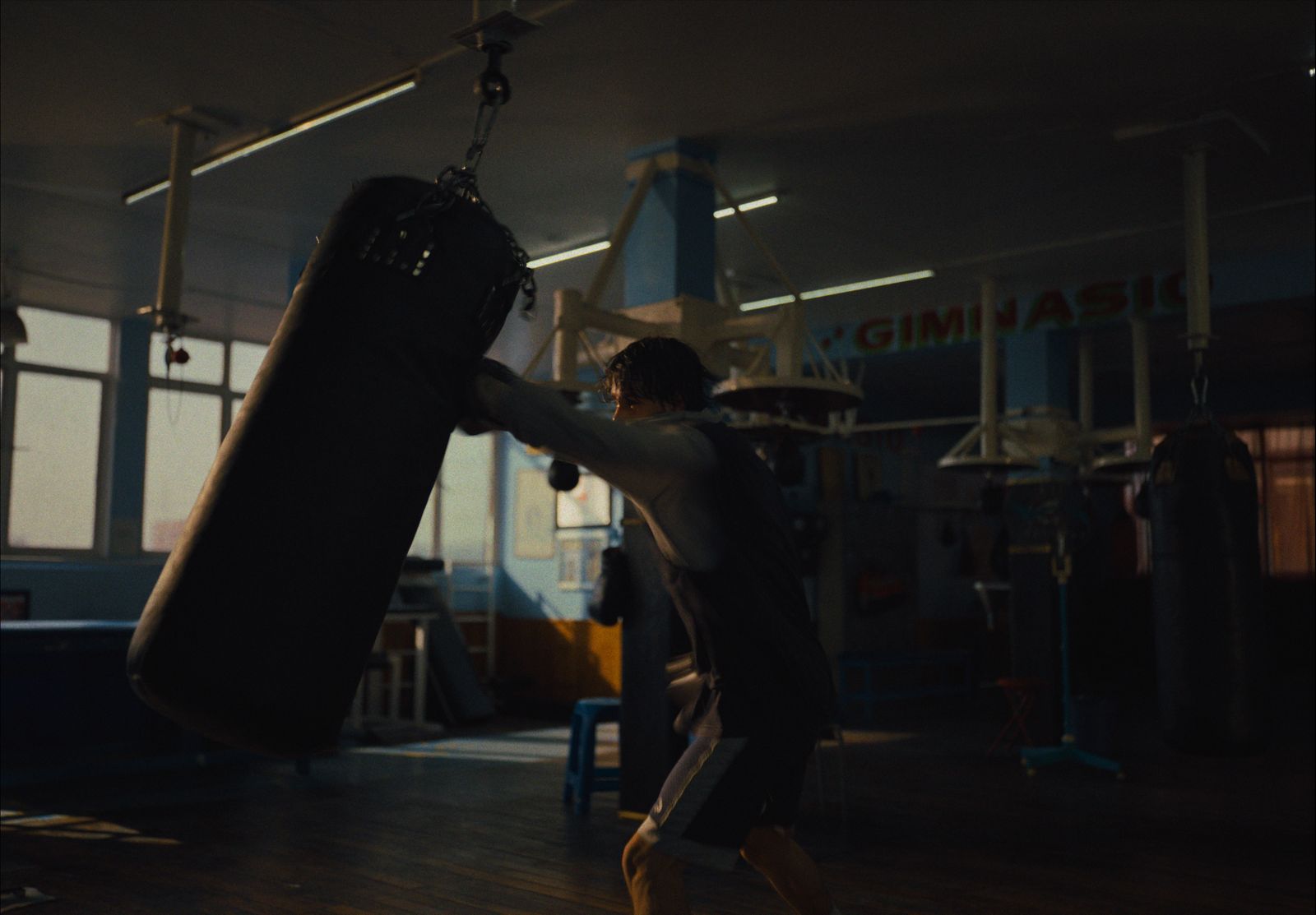 a man in a gym with a punching bag