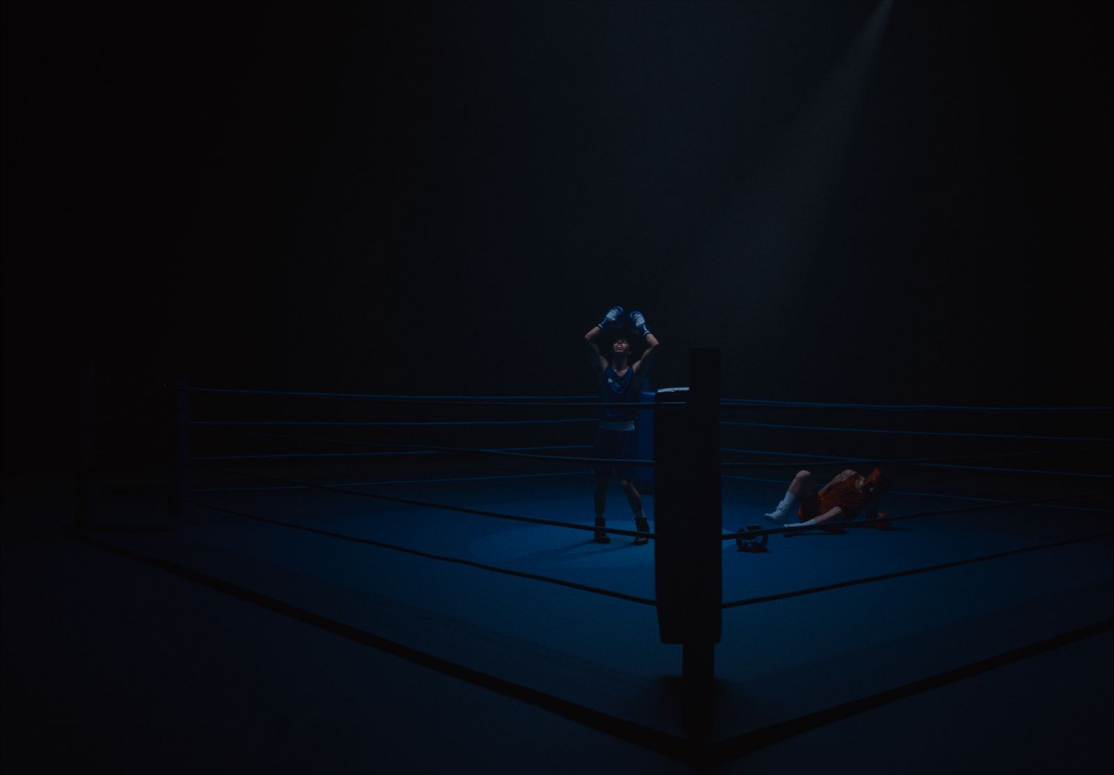 two people in a boxing ring in the dark