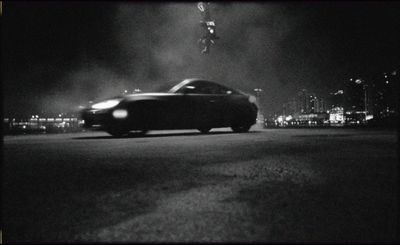 a black and white photo of a car in the dark