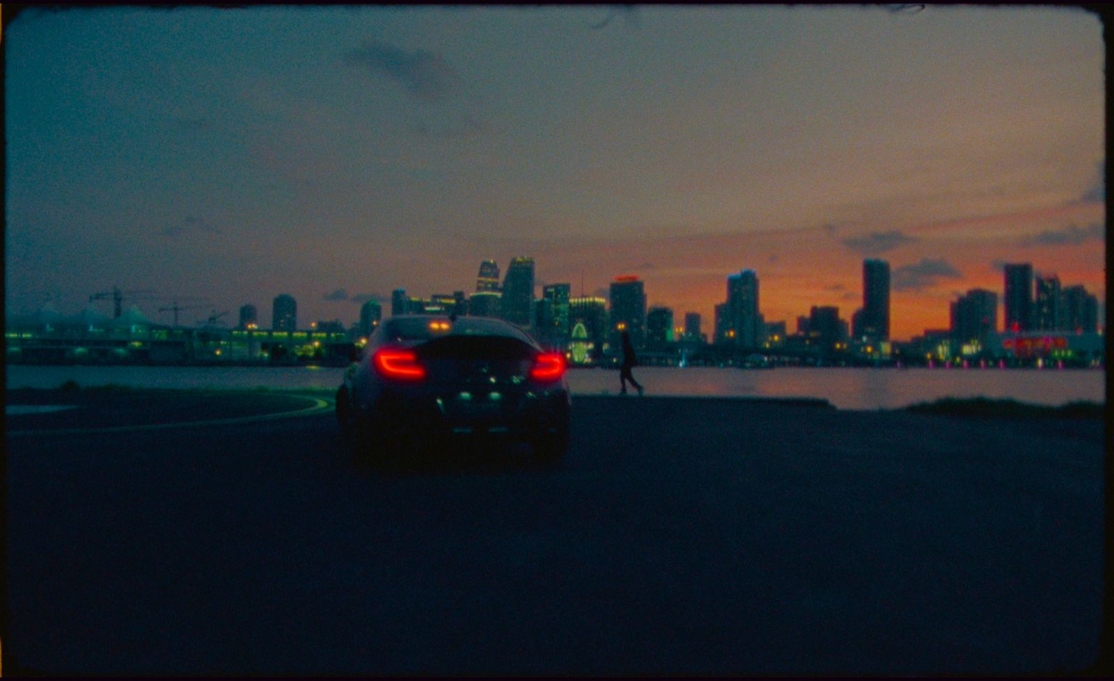 a car driving down a street next to a large body of water