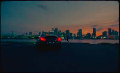 a car driving down a street next to a large body of water