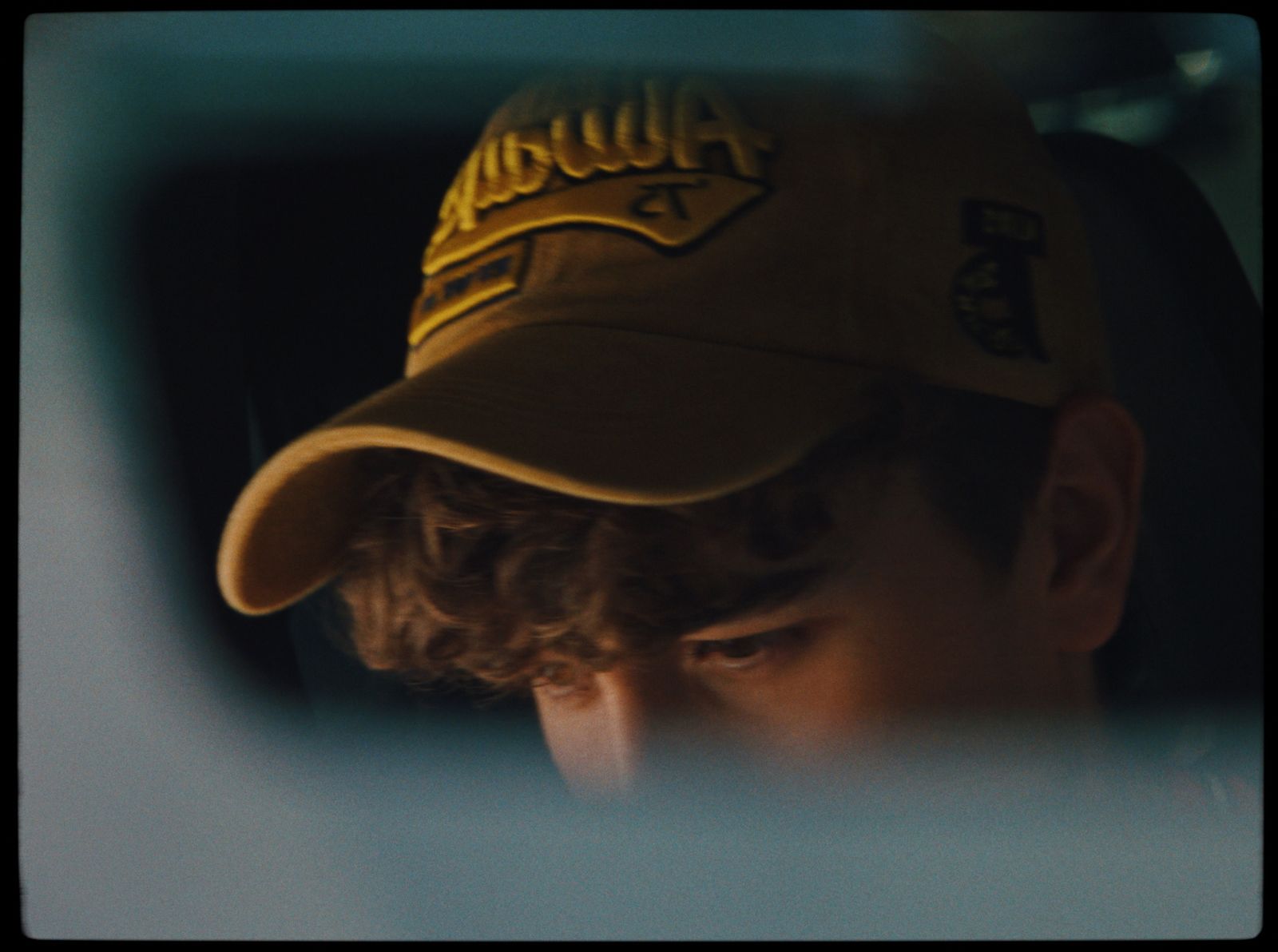 a man in a baseball cap looking at his reflection in a mirror