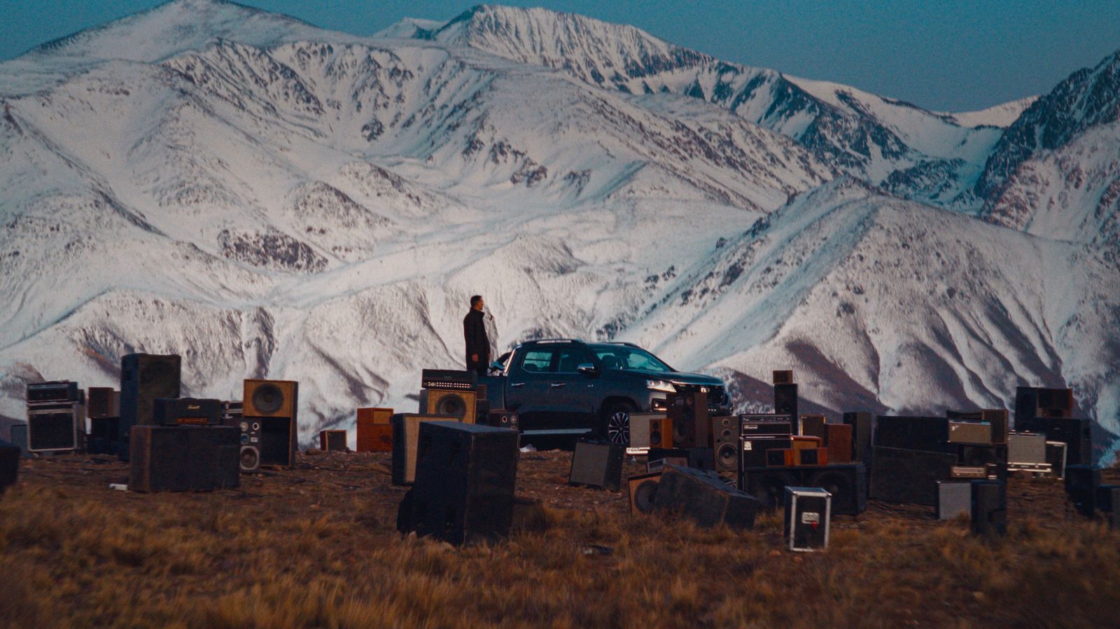 a car parked in a field with a mountain in the background