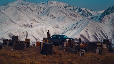 a car parked in a field with a mountain in the background