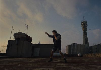 a man standing on top of a dirt field next to a soccer ball