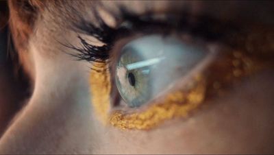 a close up of a person's eye with yellow and blue contacts