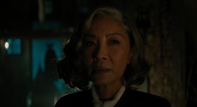 an older woman in a dark room looking at the camera