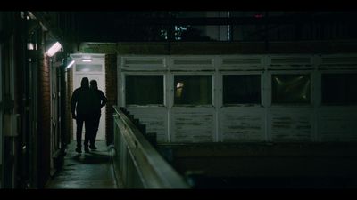 a person walking down a dark hallway at night