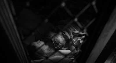 a man and a woman are sleeping in a cage