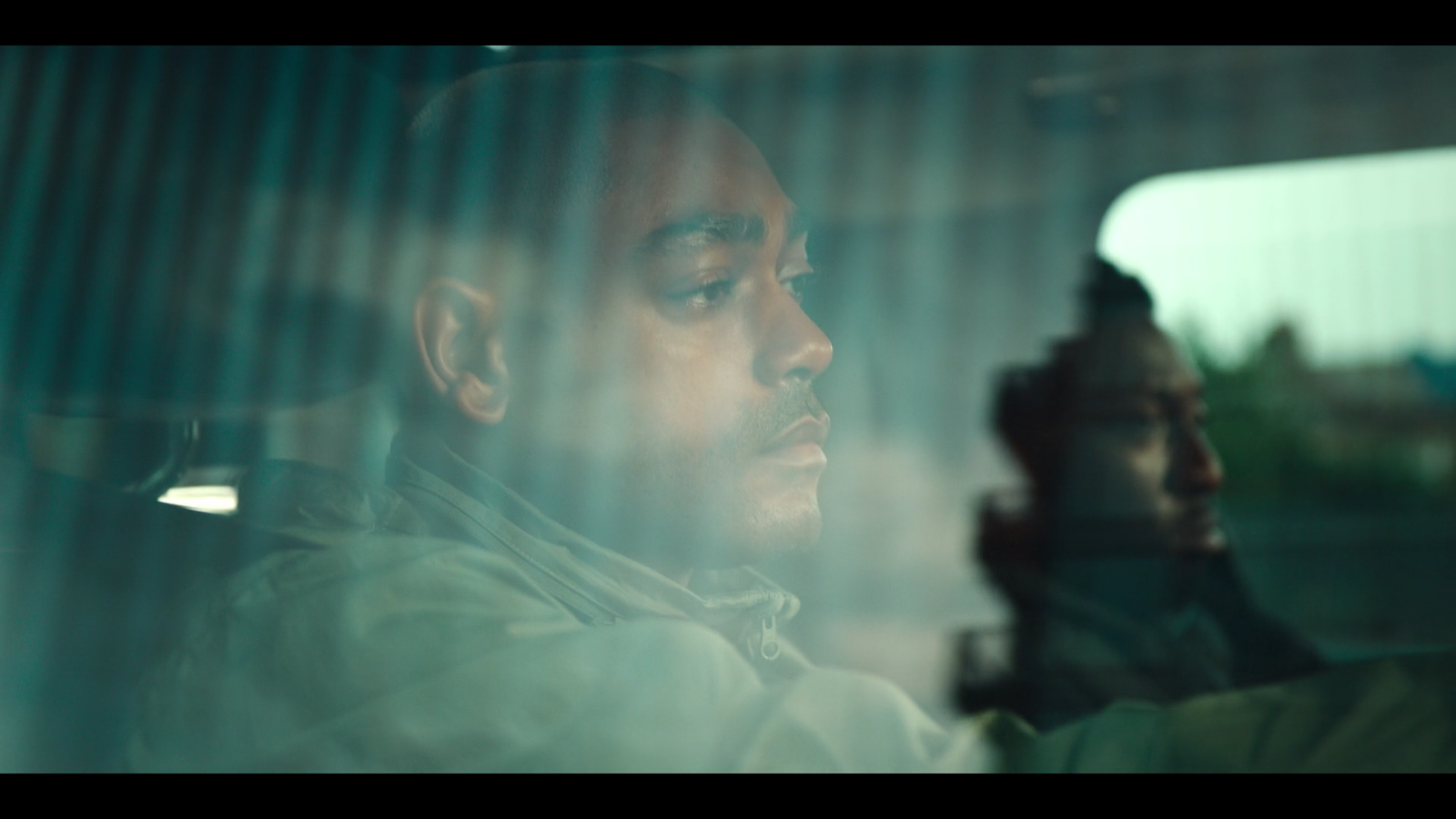 a man sitting in a car looking out the window