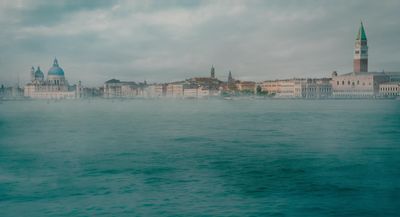 a large body of water with buildings in the background