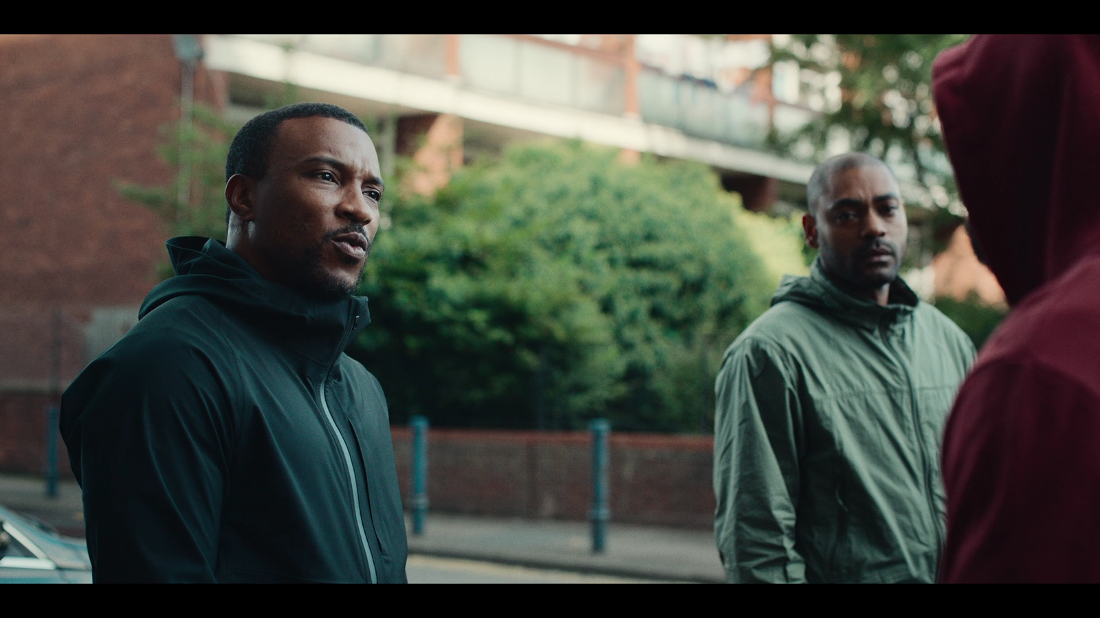 two men standing next to each other on a street