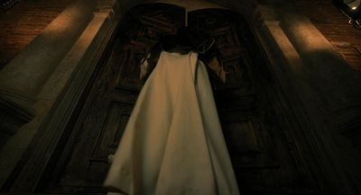 a woman in a white dress standing in a doorway