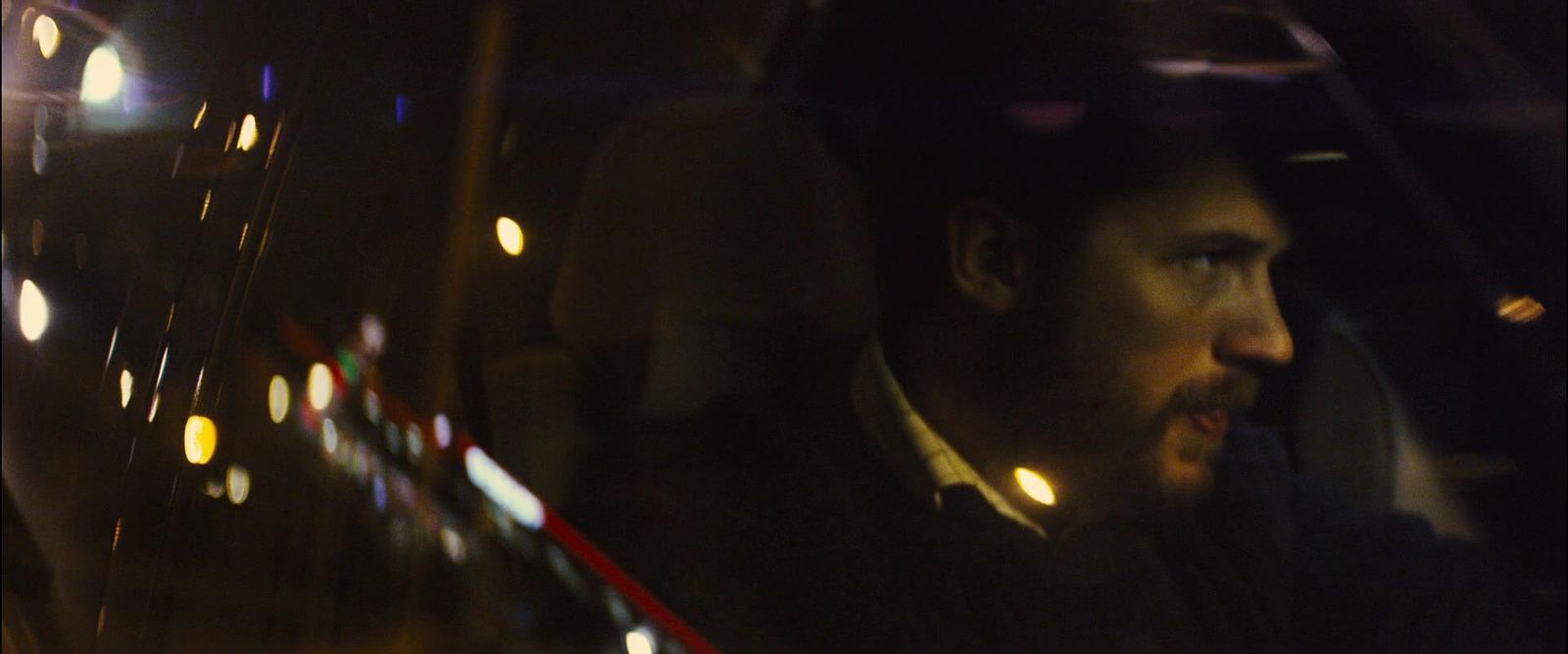 a man sitting in a car at night