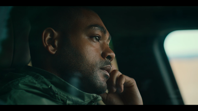 a man sitting in a car looking out the window