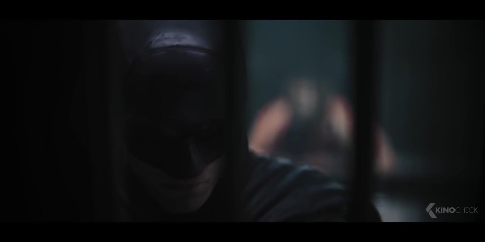 a man in a dark room with a batman mask