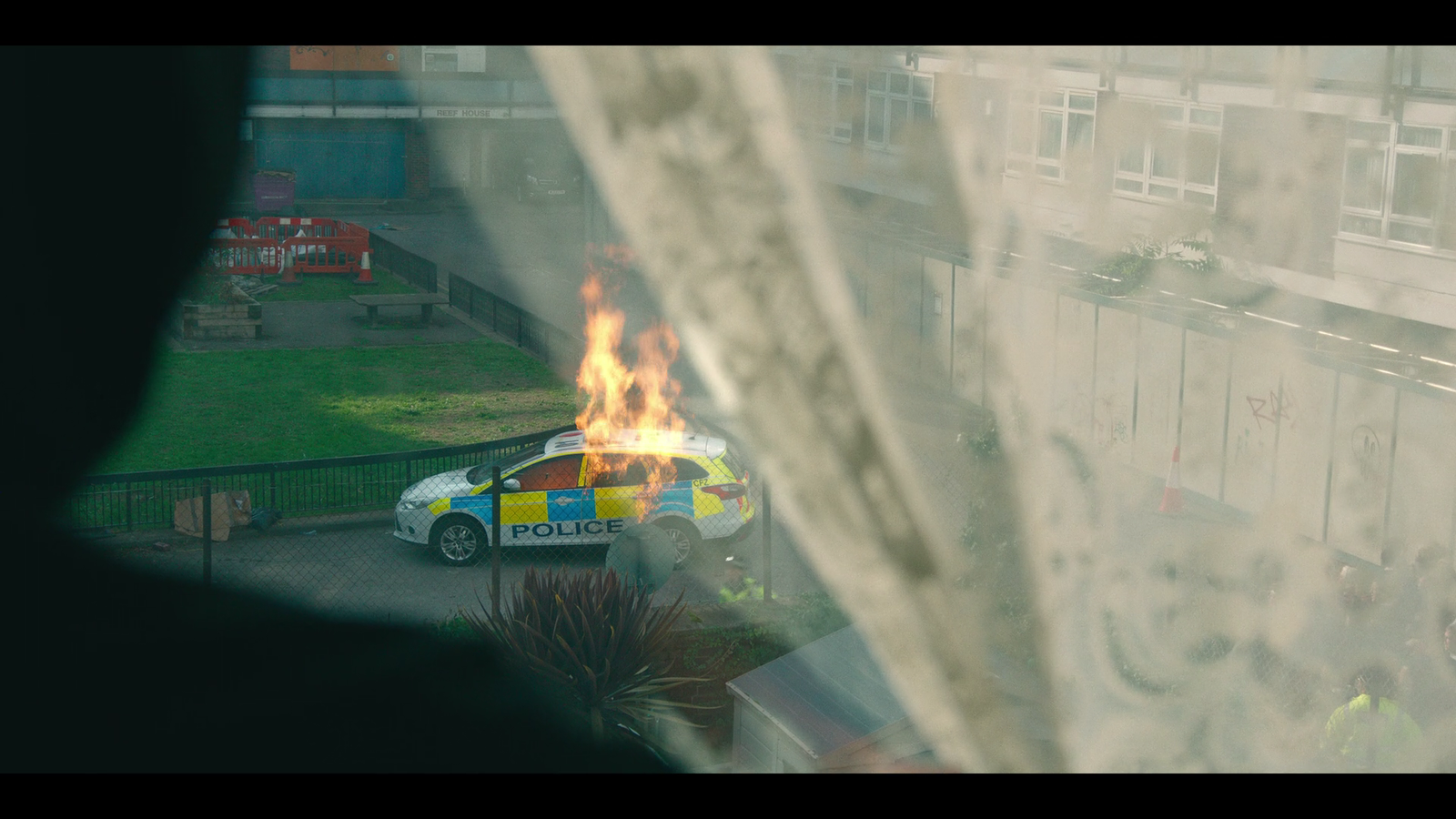 a police car on fire in front of a building