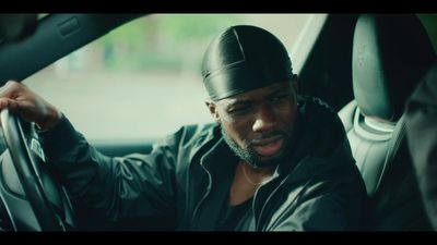 a man sitting in a car holding a steering wheel