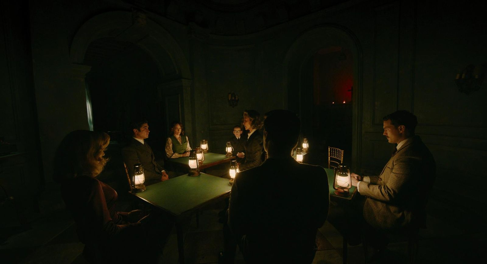 a group of people sitting around a table with candles