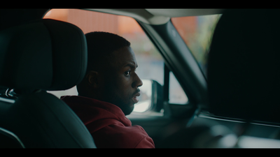 a man sitting in a car looking out the window