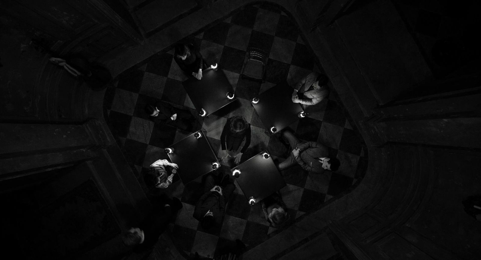 a black and white photo of a group of people sitting at a table