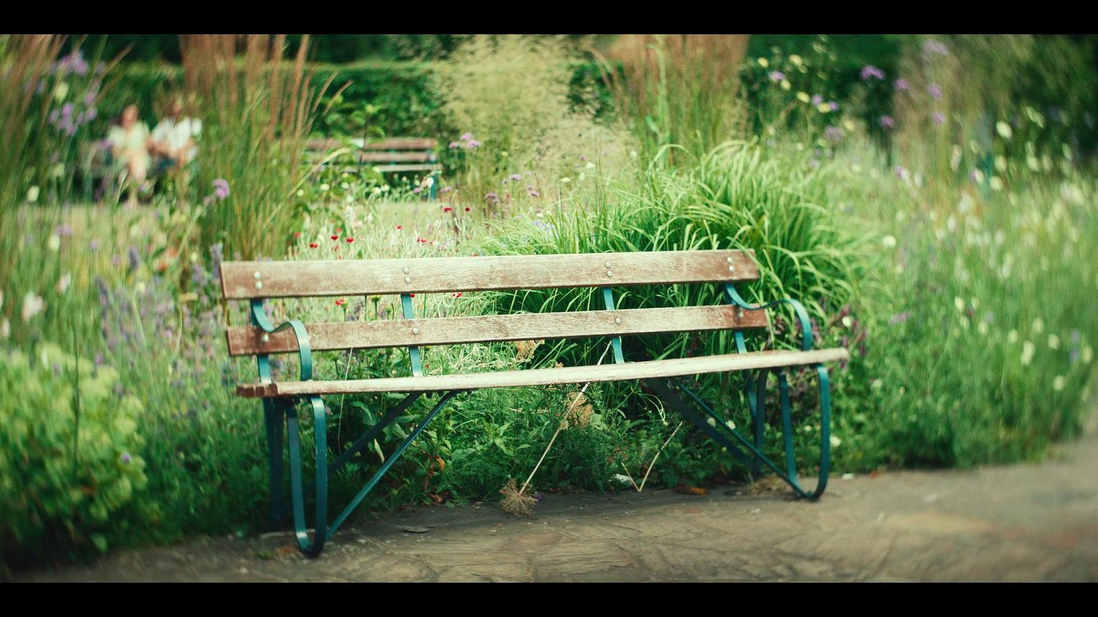 a wooden bench sitting in the middle of a garden