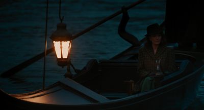 a woman sitting in a boat holding a wine glass