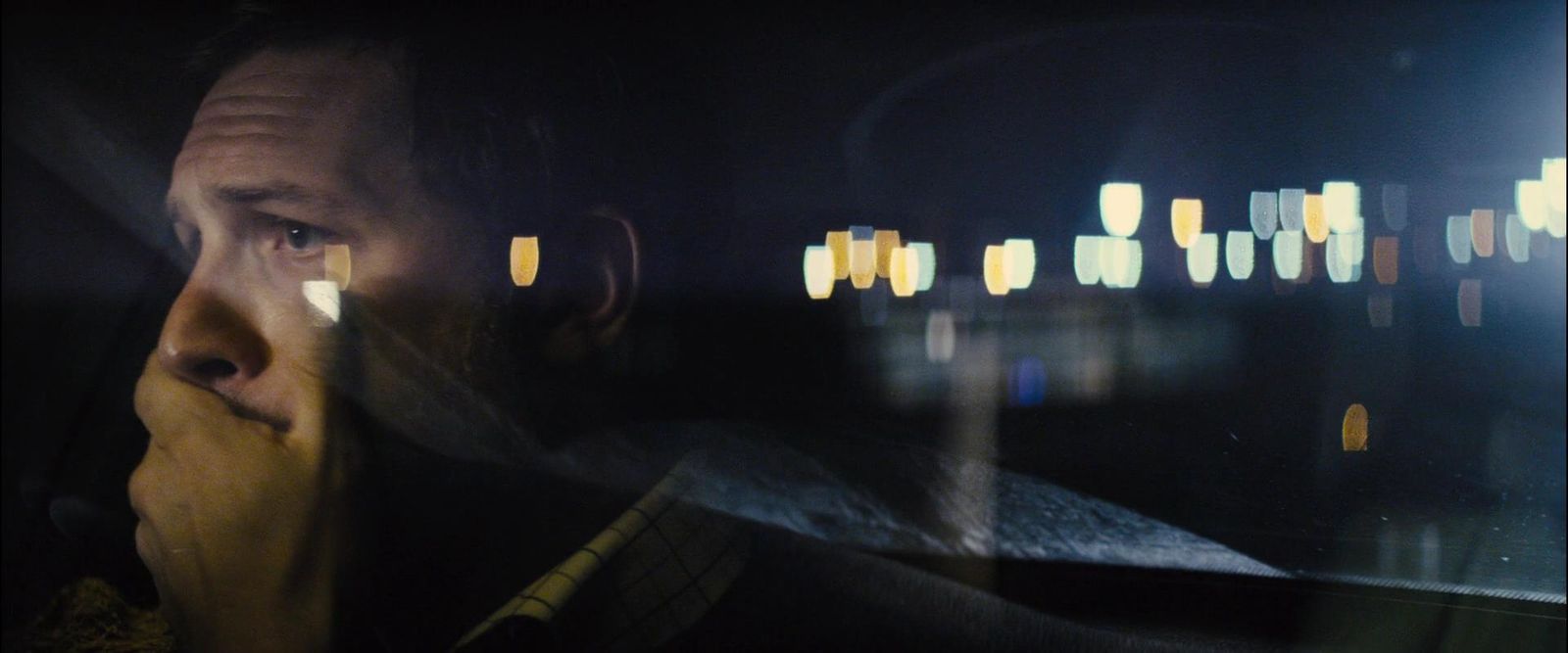 a man sitting in the passenger seat of a car at night