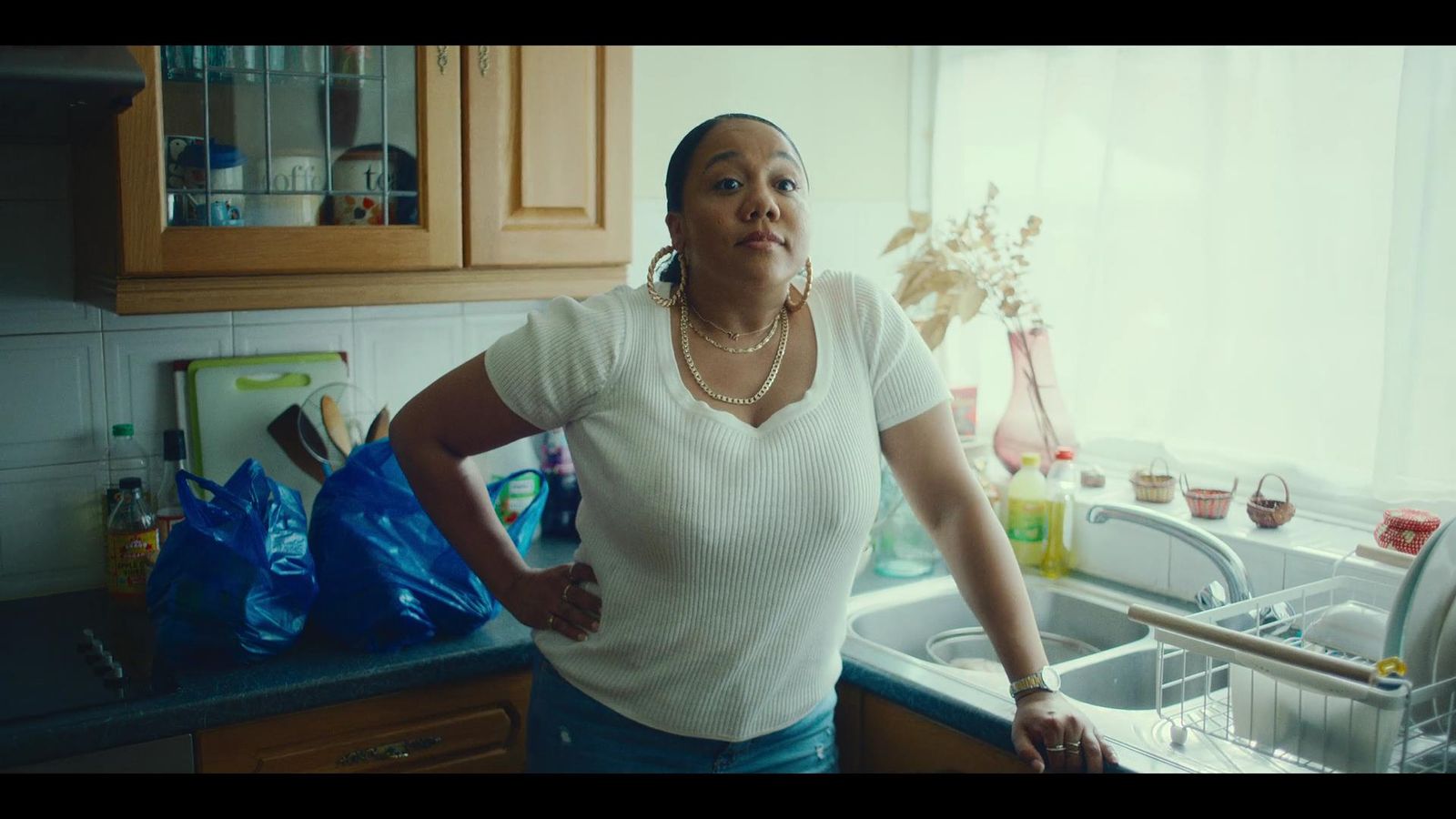 a woman standing in a kitchen next to a sink