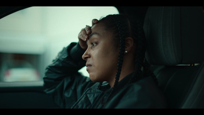 a woman with braids sitting in a car