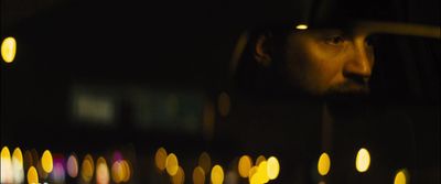 a man looking out of a car window at night