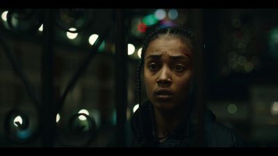 a woman with dreadlocks stares into the camera