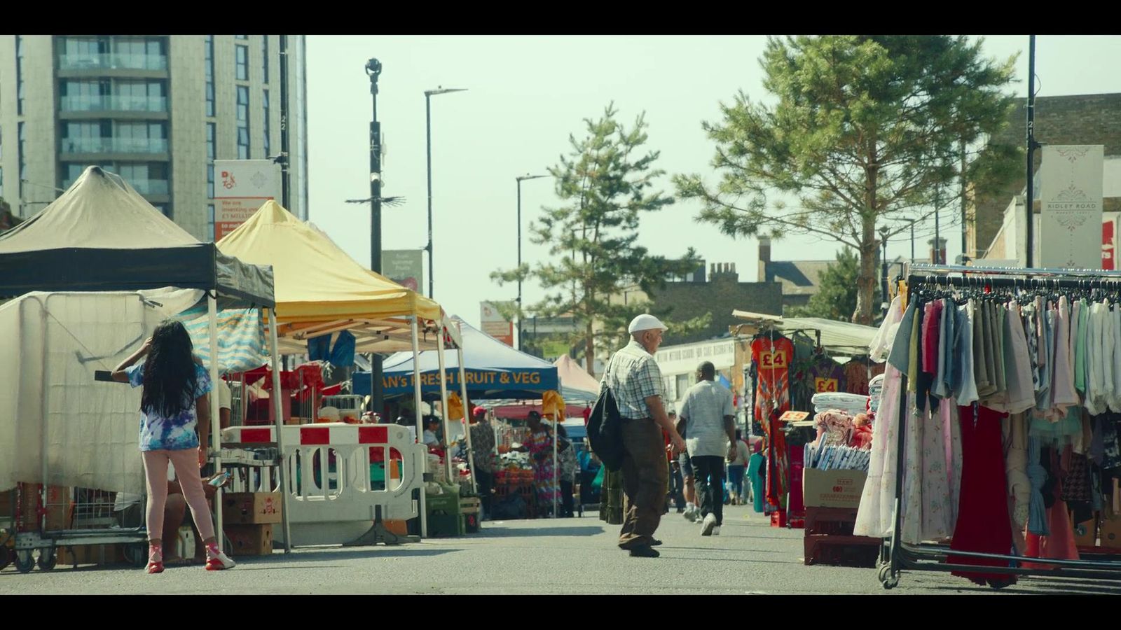 a group of people walking down a street next to tents