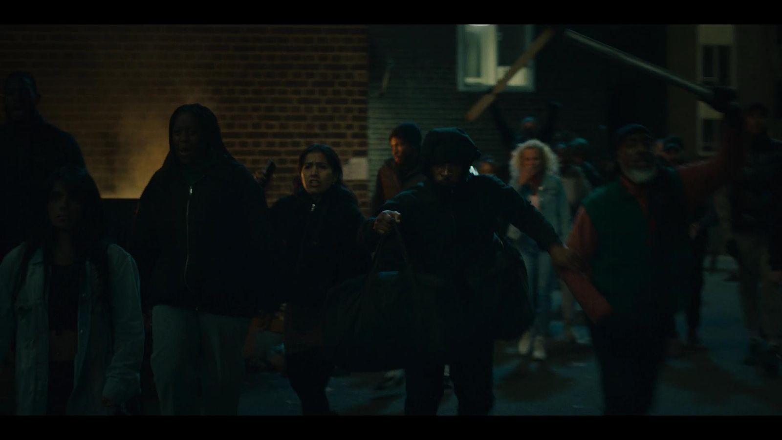 a group of people walking down a street at night