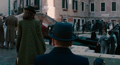 a group of people standing around a boat in a canal