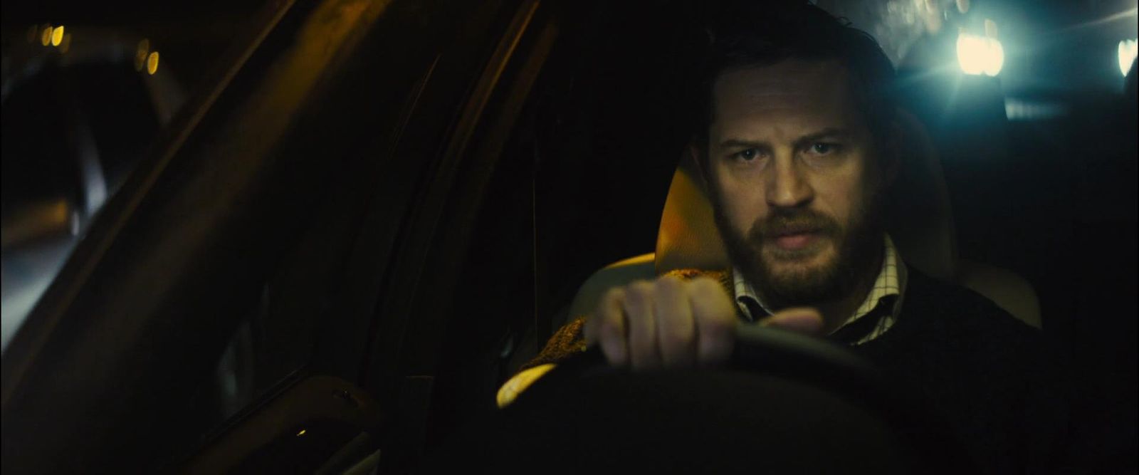 a man driving a car in the dark