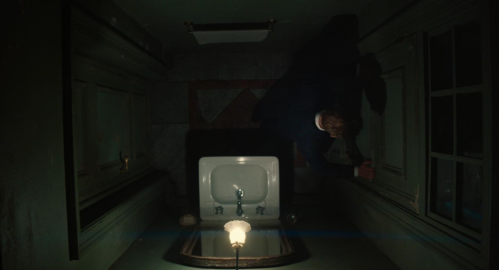 a person standing next to a urinal in a dark room