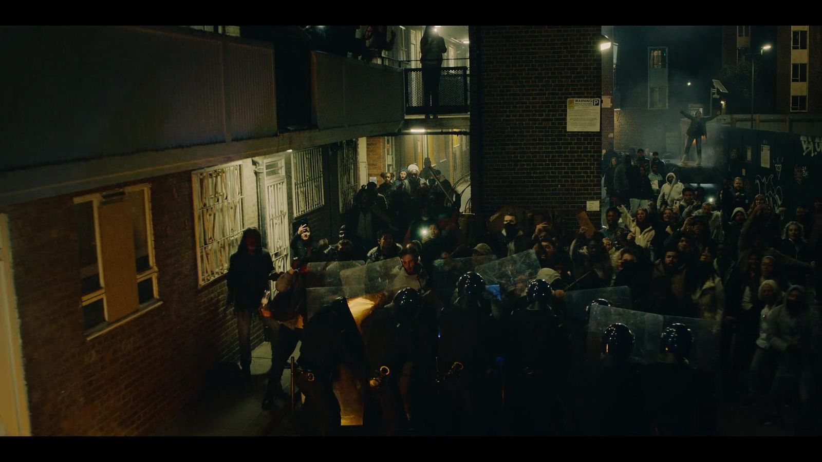 a crowd of people standing around a building at night