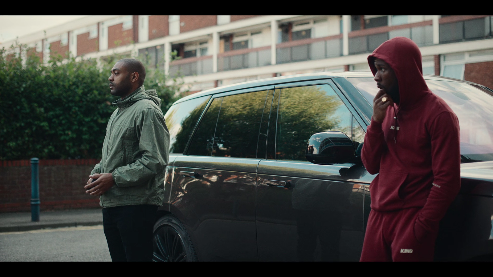 a couple of men standing next to a car