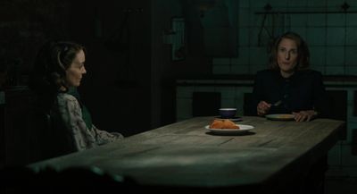 a woman sitting at a table with a plate of food